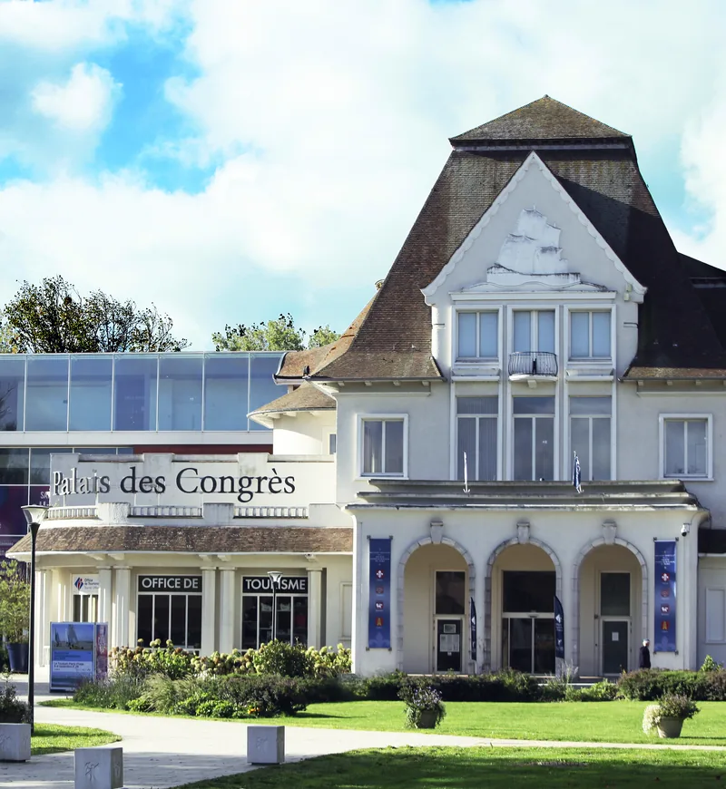 La façade du Palais des Congrès du Touquet et ses pelouses, sous un ciel nuageux
